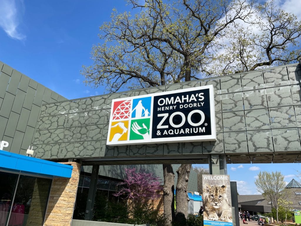 Omaha Henry Doorly Zoo and Aquarium Entrance with zoo sign over an archway.