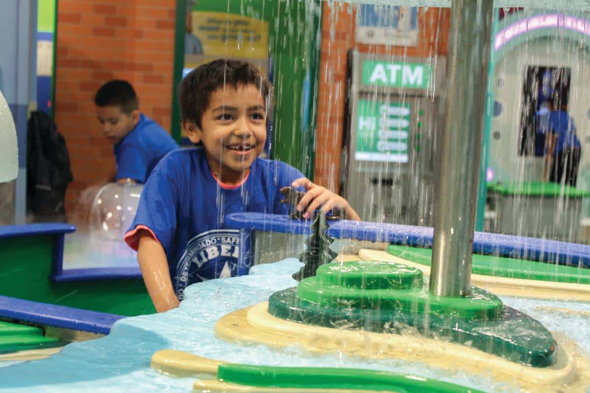 Child playing in a water feature within the Children's Museum.
